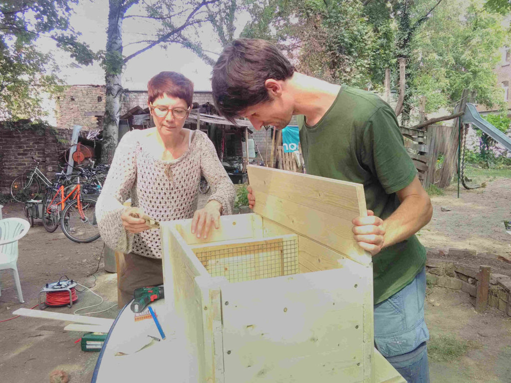 Workshopteilnehmerin und Raphael schrauben die letzten Holzteile zusammen