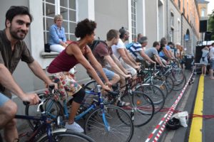 Menschen auf Fahrrädern strampeln für Strom