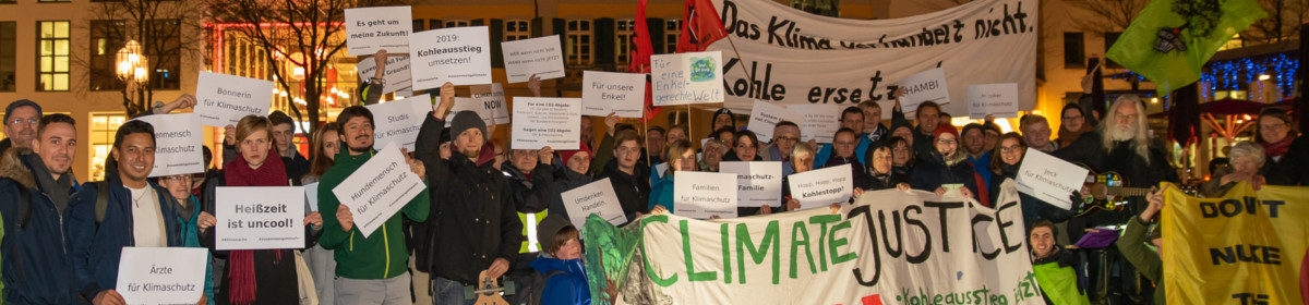 Menschen mit Klimaschutztransparenten