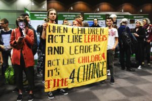 Junge Menschen mit Banner "When children act like leaders and Leaders act like childrein its Time for Change"
