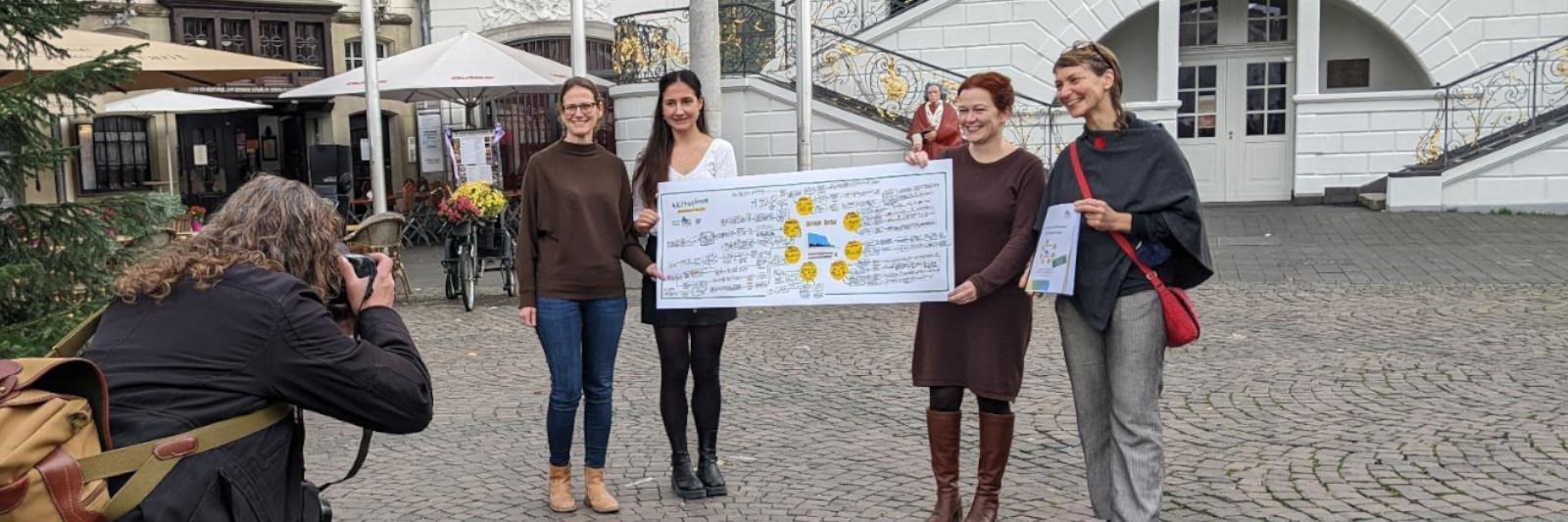 Vor der Bonner Rathaus übergeben Bürgerinnen das Transparent mit dem Klimaaktionsplan an Oberbürgermeisterin Katja Dörner und Gesa Maschkowski Mitinitiatorin von Bonn4Future hält den 150seitigen Plan in der Hand