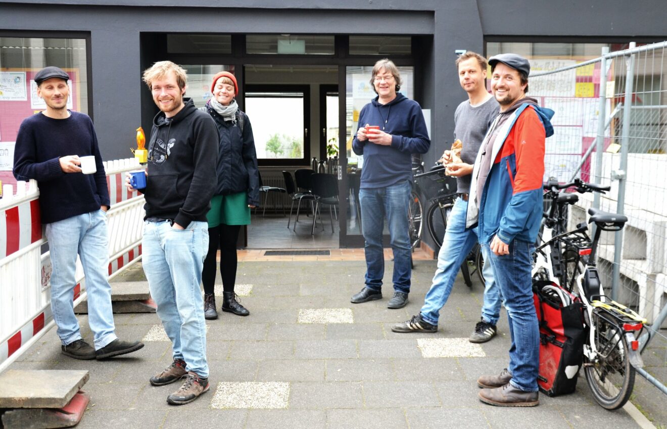 6 Personen am Eingang des Bonn im Wandel Büros in der Budapester Straße 7 lachen in die Kamera