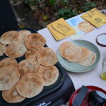 links liegt ein Stapel kleiner runder Pfannekuchen, rechts ein Teller, Marmelade und Postkarten von Bonn4Future PopUP Atelier